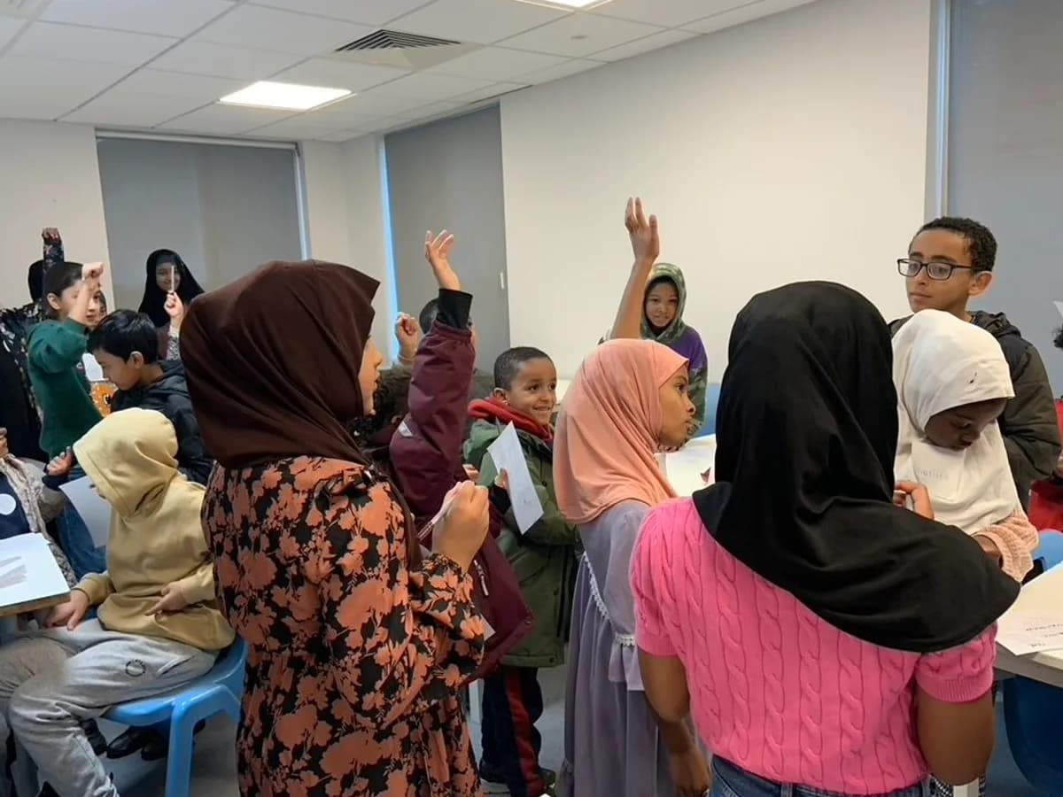 Pupils with their hands up during a lesson