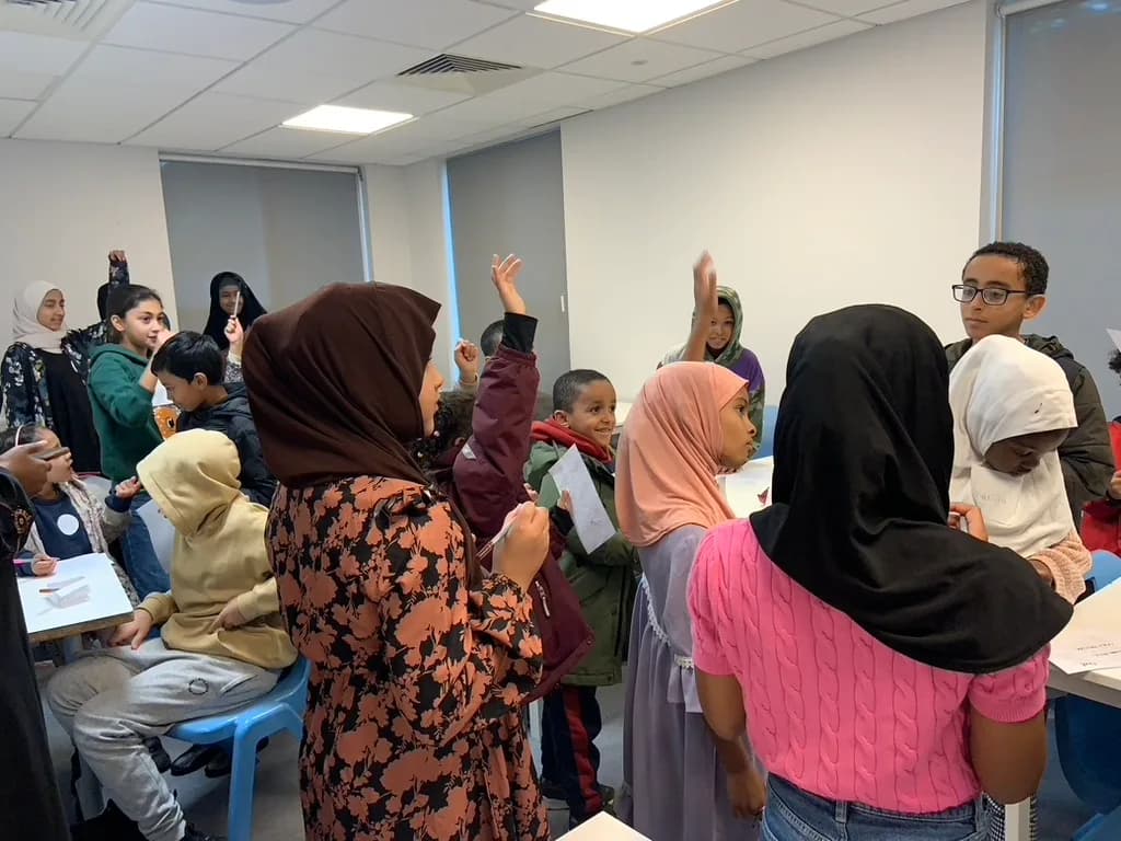 Pupils with their hands up during a session