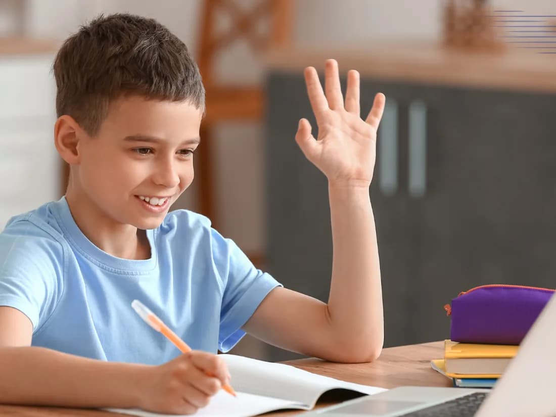 A pupil raising his hand during a live online lesson at home